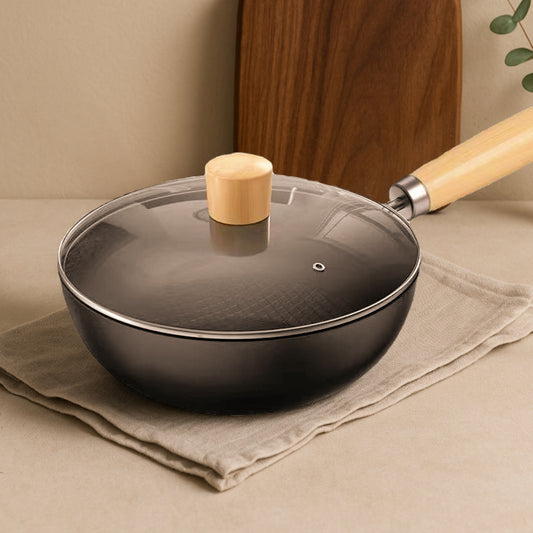 Black frying pan with a wooden handle and lid on a beige surface