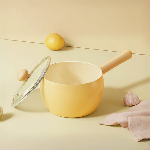 Cute and pretty yellow pot with wooden handle and lid on a light surface, solo cooking, Mini pot with Ceremic coating, non-stick.